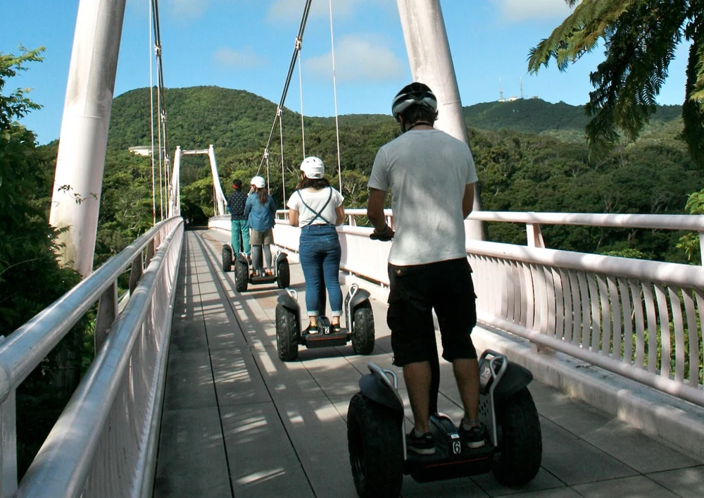 tourists on a segway passing a bridge in Banna Park