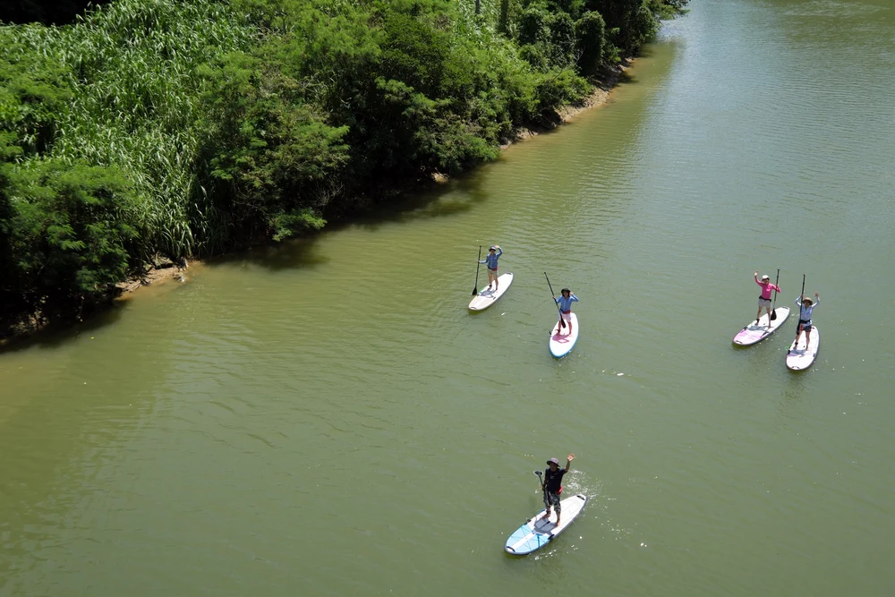 people paddleboarding in in Hijya River in Japan